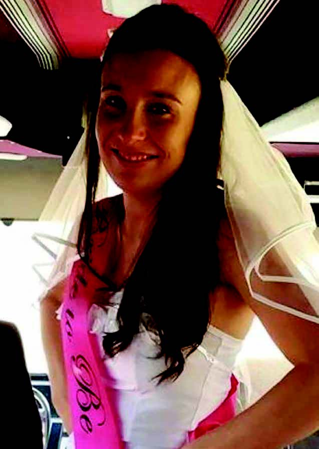 Stephanie Scott wearing a wedding dress and smiling while posing for a photo.